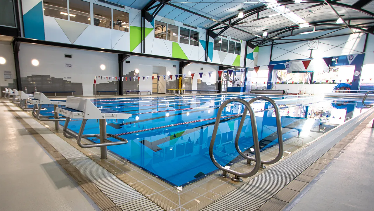 The interior of St Michael's Grammar School's state-of-the-art Aquatics Centre, showing the indoor heated pool and lane markers.