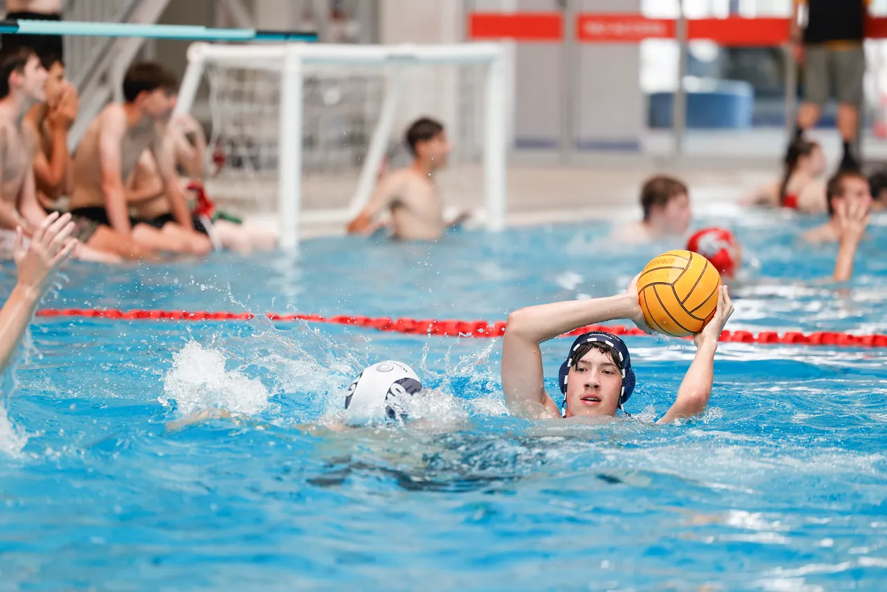 A St Michael's Grammar School student prepares to throw during a water polo match in an indoor pool.