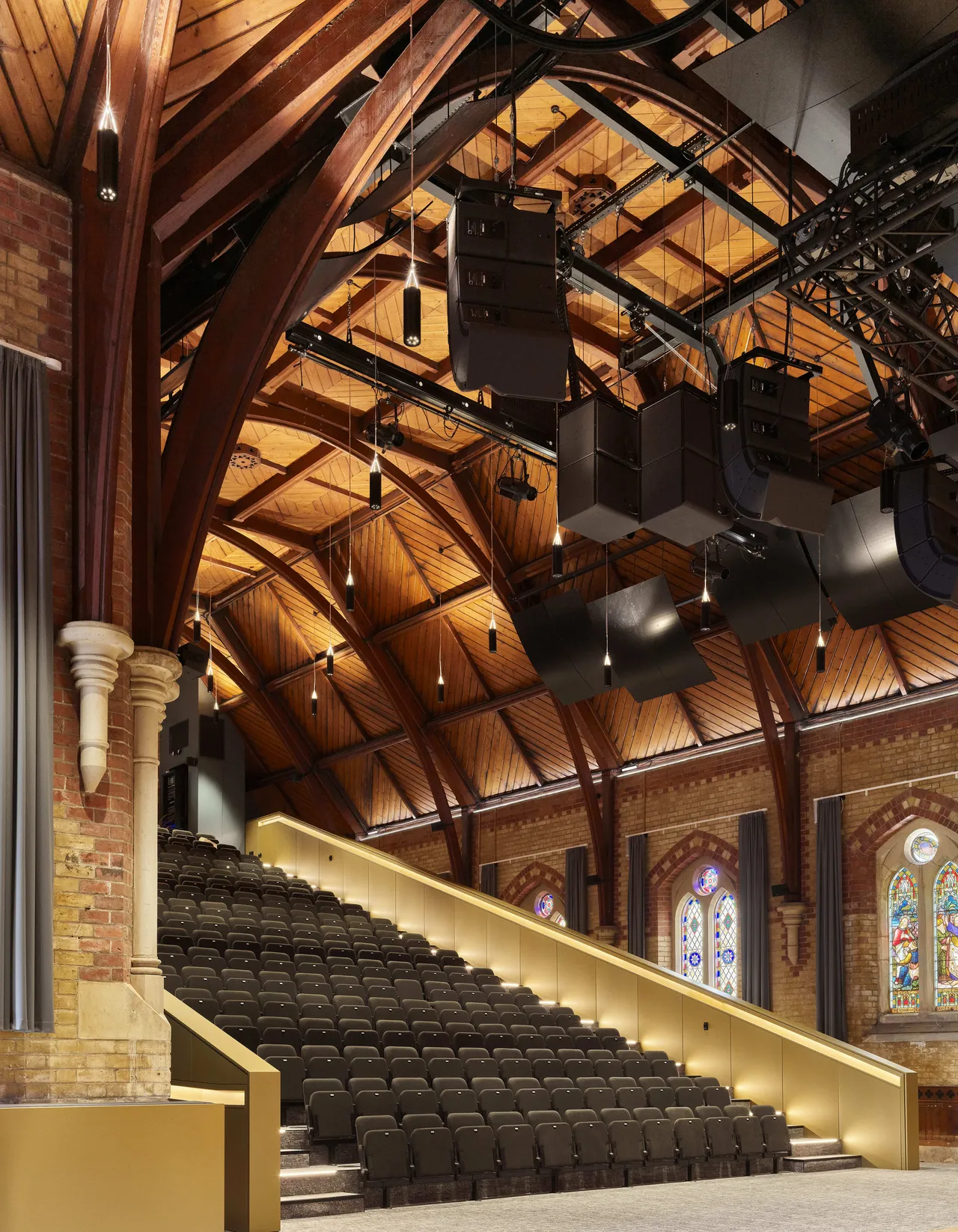 The interior timber roof and lighting rig of St Michael's Grammar School's performing arts venue, showcasing its heritage architecture alongside modern production facilities.