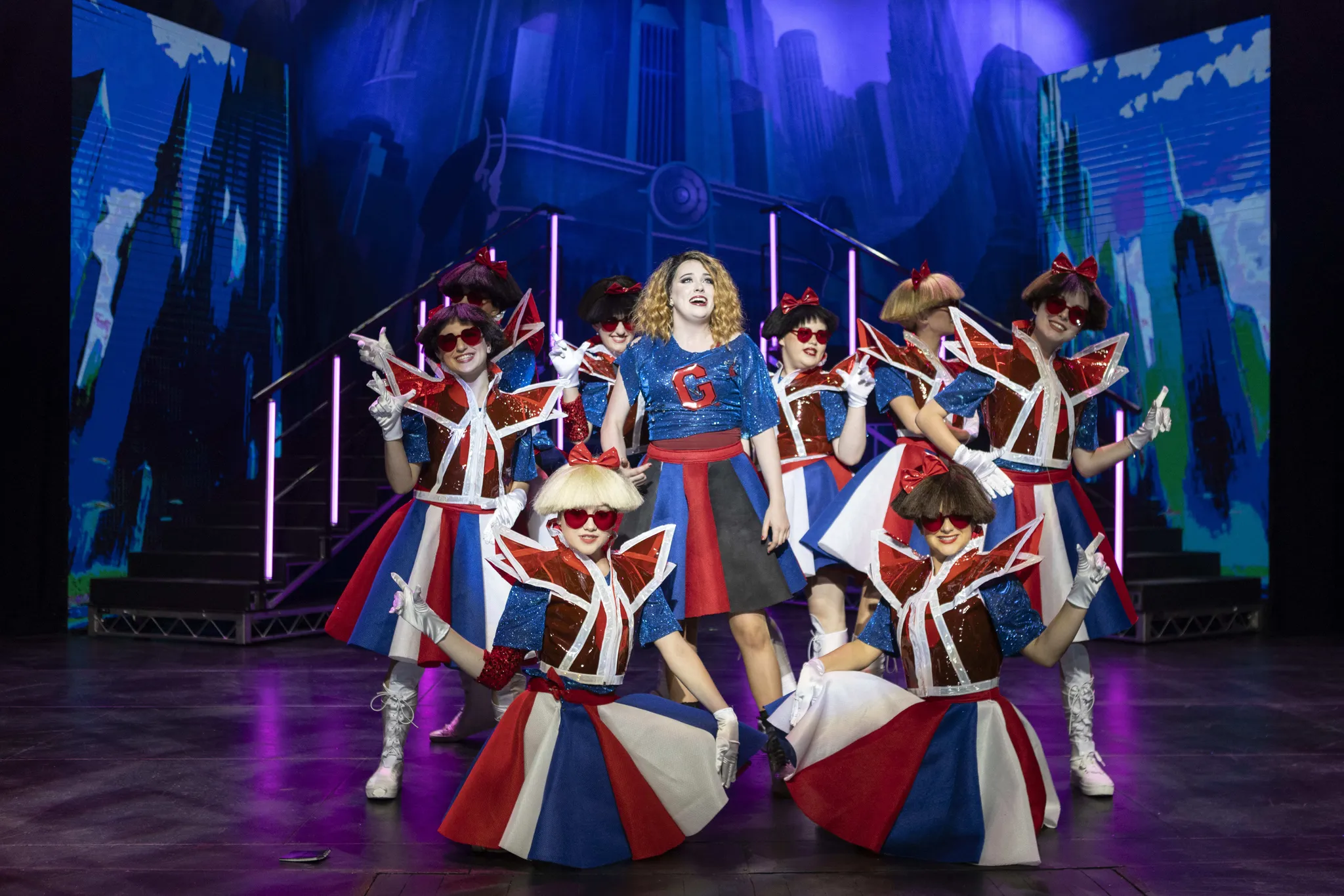 St Michael's Grammar School performers on stage during a school production, with theatrical lighting and costumes.